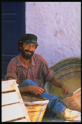 Un home en mànigues de camisa a la casella situada al costat de les cistelles de vinya