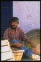 Un uomo in maniche di camicia la casella accanto a ceste con viti