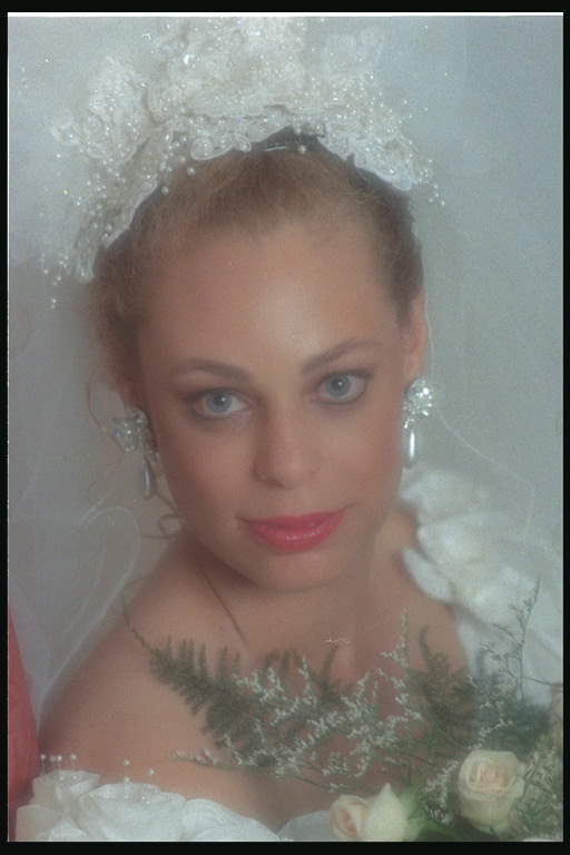 Жена в сватбена рокля и букет цветя