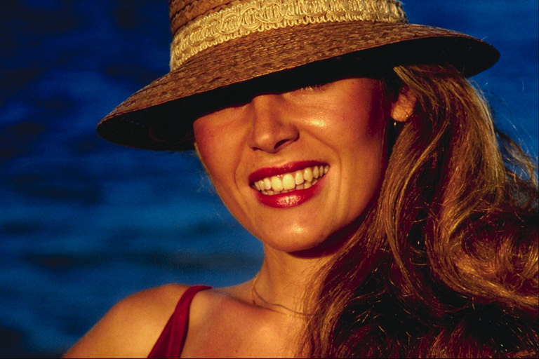 Mergina į skrybėlę su šypsena ant veido savo