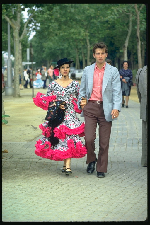 Para. En jente i en kjole med en lys rosa rysjer og en svart lue