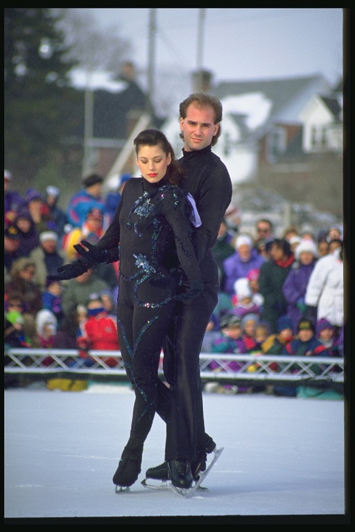 A pair of figure skaters in black suits