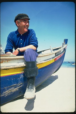 Mannen på stranden med båt