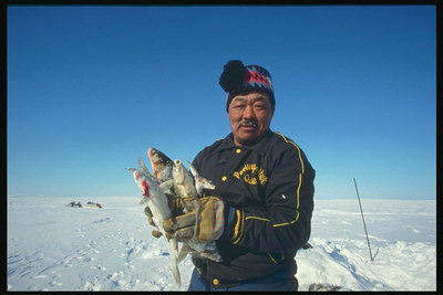 Zima. Muž s čerstvými rybami v ruce