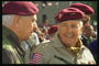 Мужчины в военных костюмах с бордовыми биретами