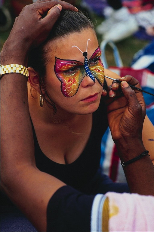 Slika metuljev pisane barve na obraz dekle