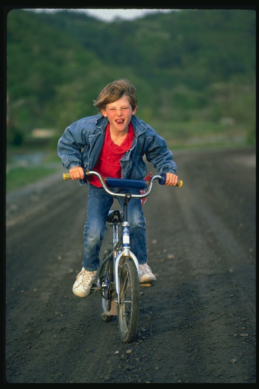 Poika rides polkupyörän
