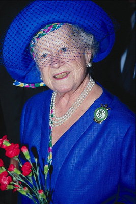 En kvinde i en blå kjole i hatten og med blomster