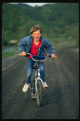A boy rides biċikletta