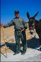 Großvater in der Wüste mit einem Esel