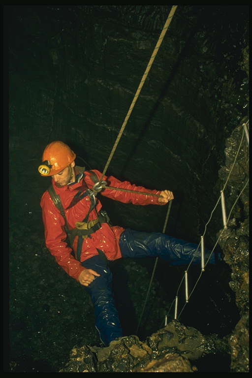 Rescuer. Seorang laki-laki berjalan di bawah kabel ke dalam gua