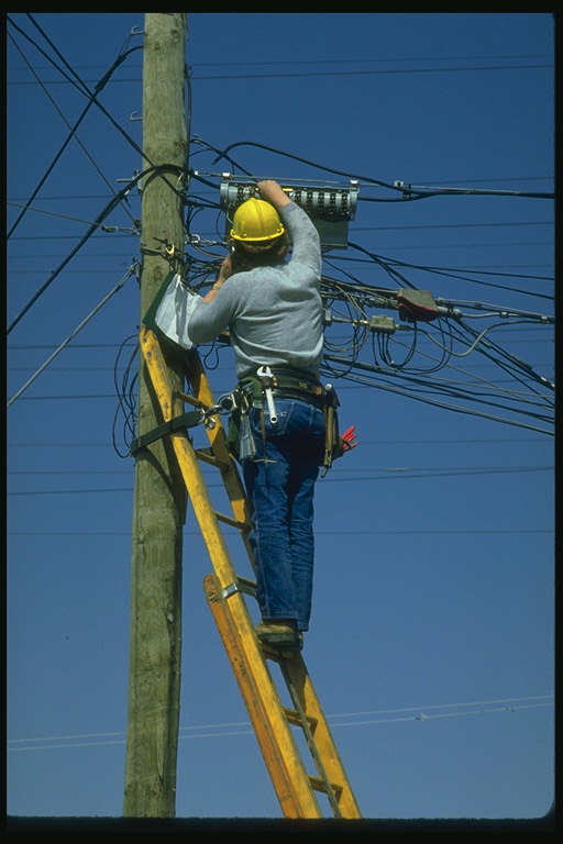 Elektriker. Ein Mann prüft die Drähte an der Stange