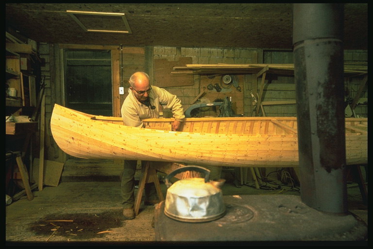 Майстер виготовляє човен з дерева