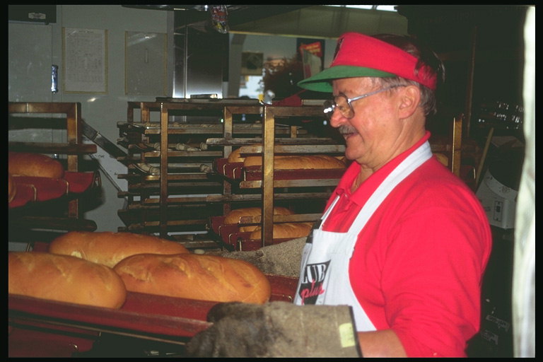 Пекарь. Мужчина выпекает хлеб