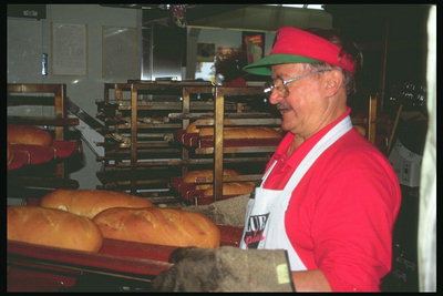 Пекарь. Мужчина выпекает хлеб