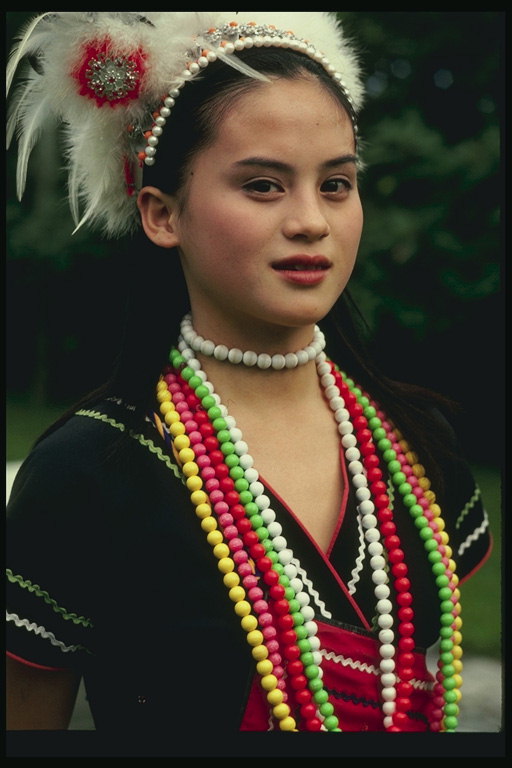 Jeune fille en costume national décorés de plumes et de perles
