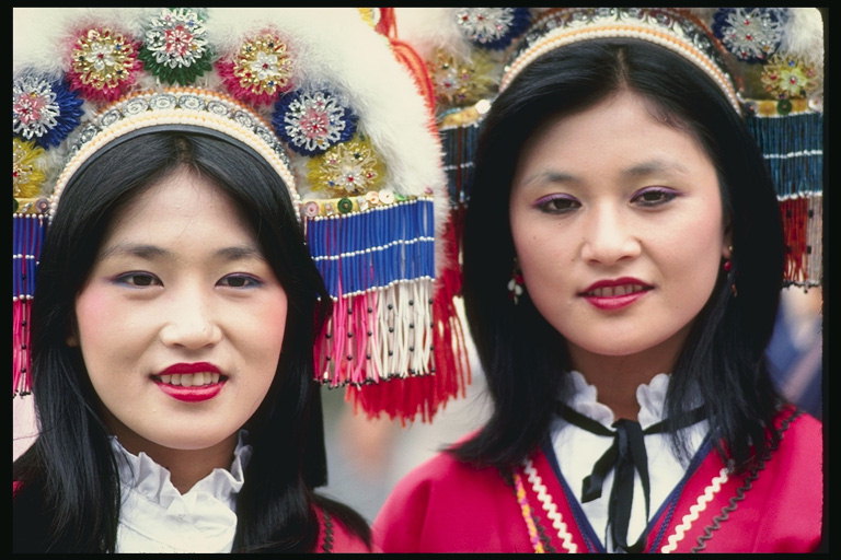 Noies en vestits nacionals amb fils, pells i flors