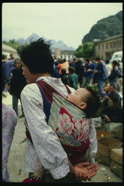 Дете в хамак на гърба на мама
