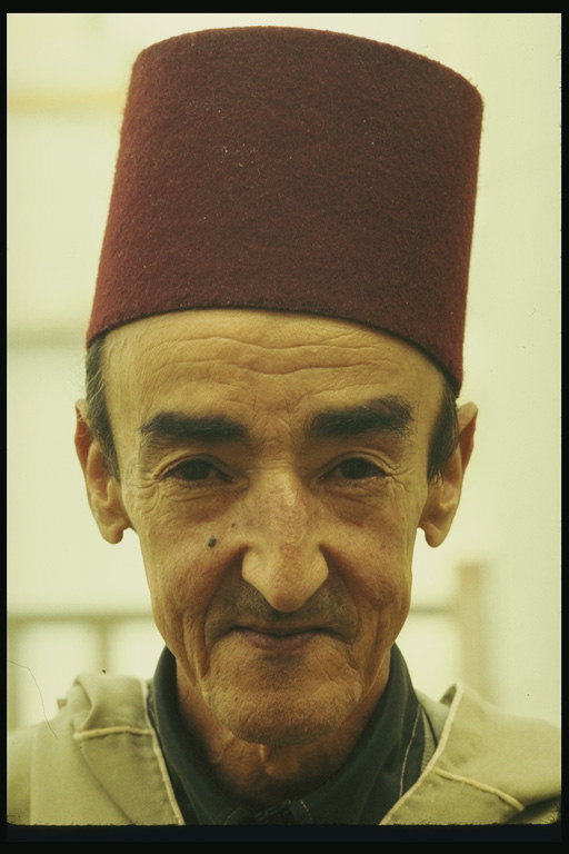 En man i en hög rödbrun hatt