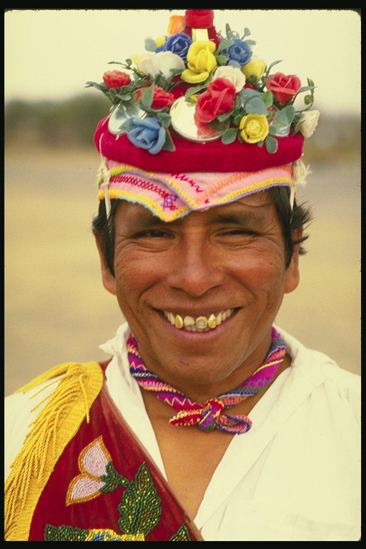 A man in a headdress with artificial flowers