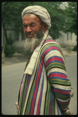Asia. En mann i en fargerik, stripete Slåbrok