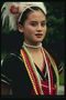 Meisje in klederdracht versierd met veren en kralen