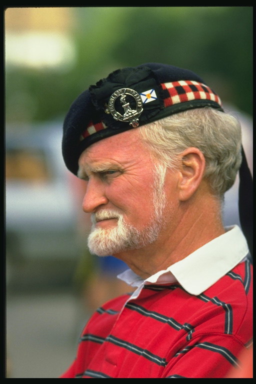 Мужчина в шляпке с гербом и красно-белой клеткой