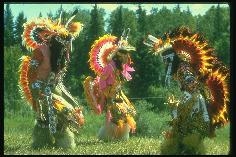 Танец индианцов. Люди в костюмах с ярких перьев и меха животных