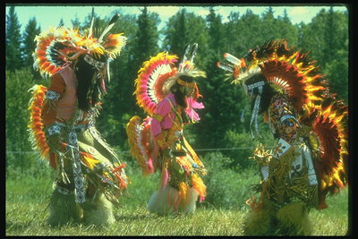 Танец индианцов. Люди в костюмах с ярких перьев и меха животных
