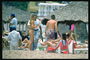 Компания людей на пляже возле зонтика с травы