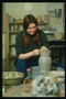 Девушка изготовляет вазу с глины