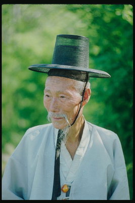 Un home do sombreiro negro cun material transparente