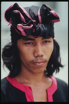 De jonge man in een zwarte sjaal met roze grenzen