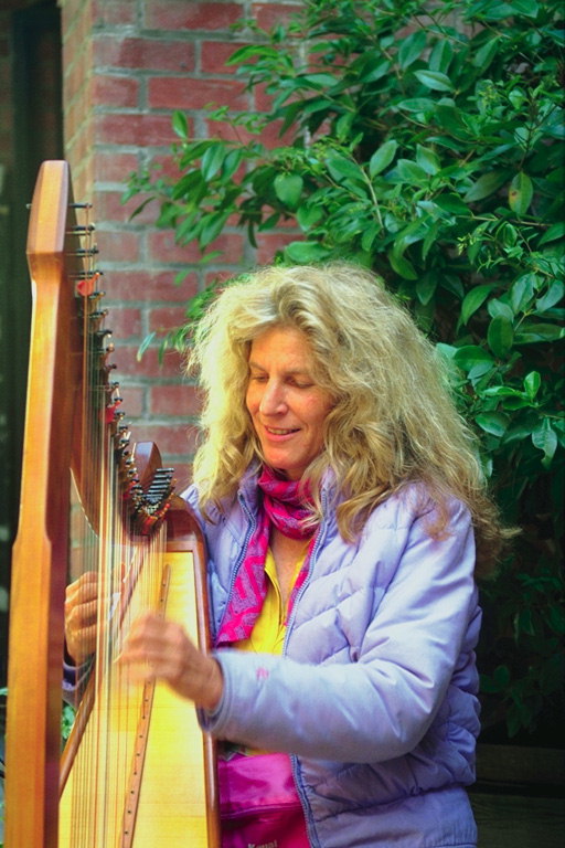 En kvinna med en harpa under väggarna i byggnaden
