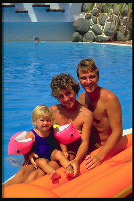 Молодая семья у бассейна