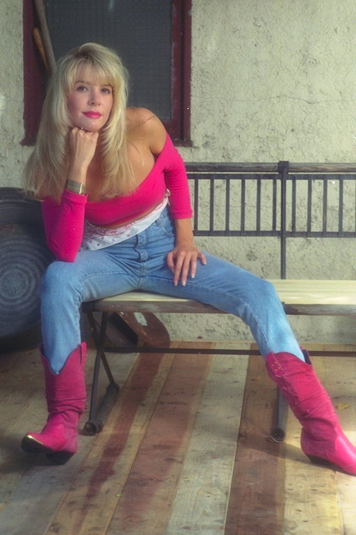 Девушка в ярко-розовой кофте и сапогах