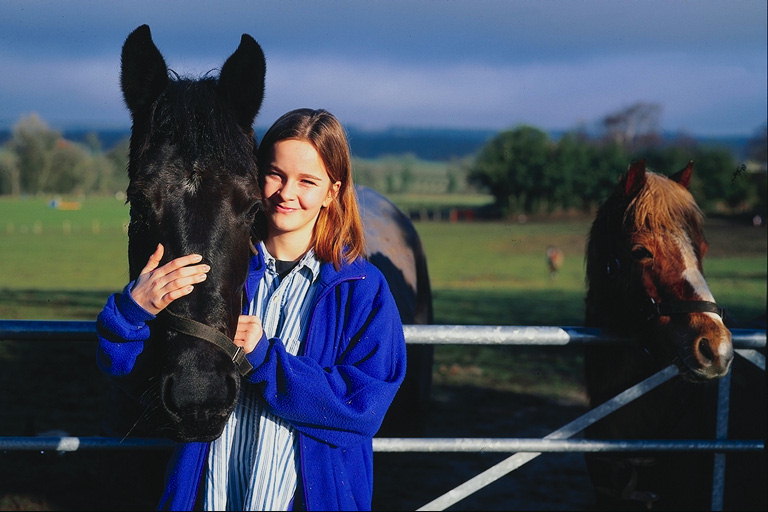 Девочка в темно-синей кофте и лошадь