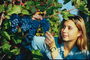 Девушка и гроздьи синего винограда