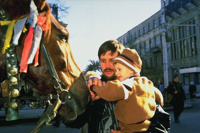 Мужчина с ребенком возле лошади