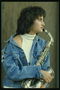 Молодая девушка играет на саксофоне