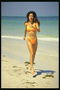 Девушка в желто-оранжевом купальнике. Бег на пляже