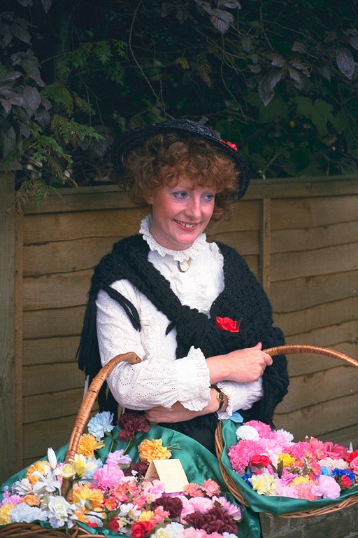 Женщина в шляпке с корзинами цветов