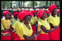 Женщины в желтых блузах, красных косынках и юбках