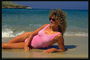 Женщина в розовом купальнике на мокром песке