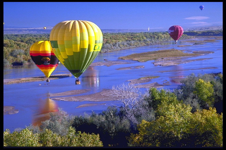 Mnohobarevné balóny nad řekou