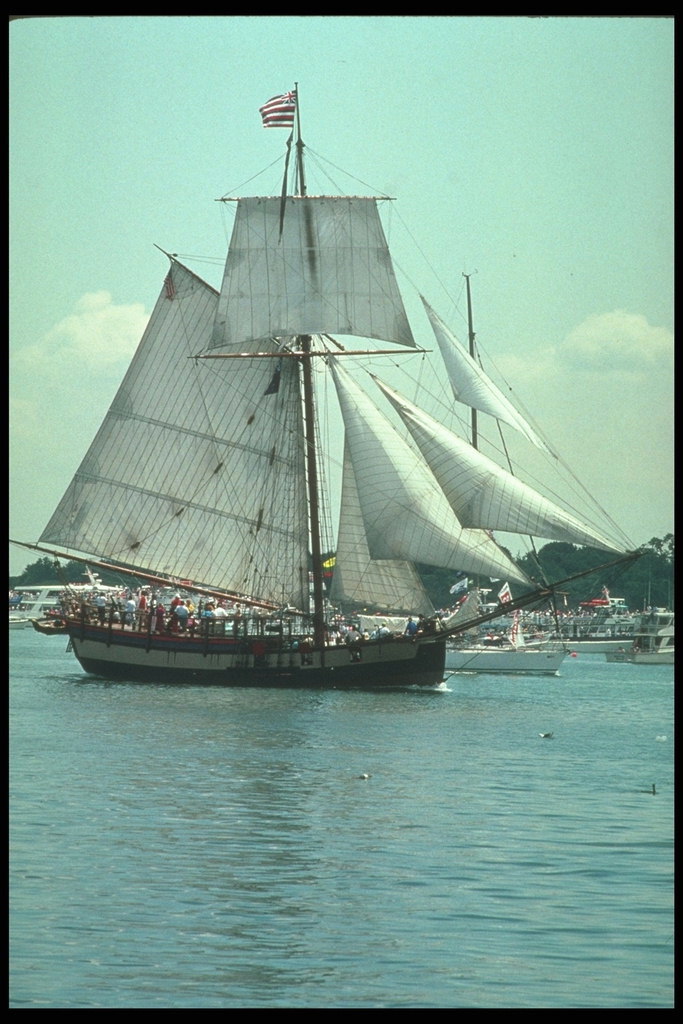 Морской парусник заполненный туристами в круизе вдоль береговой линии