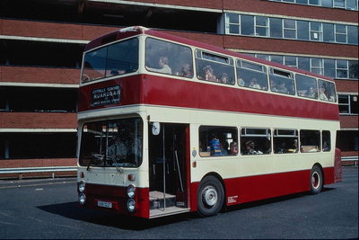 Harmony környezetben. Fehér-piros busz látható, háttérben a fehér és vörös épület