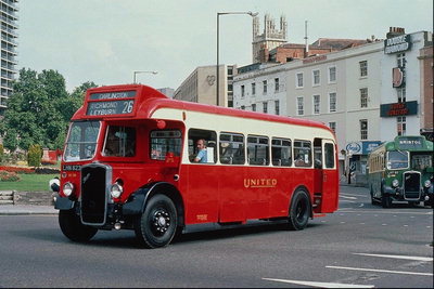Старинный красный автобус на маршруте среди городских небоскрёпов