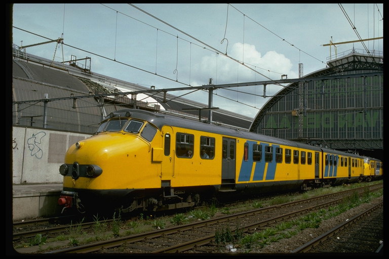 Un tren galben părăseşte tunelul în staţie de pe traseu