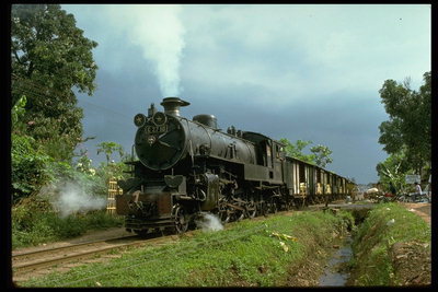 Паровозный двигатель локомотива тянет товарные вагоны